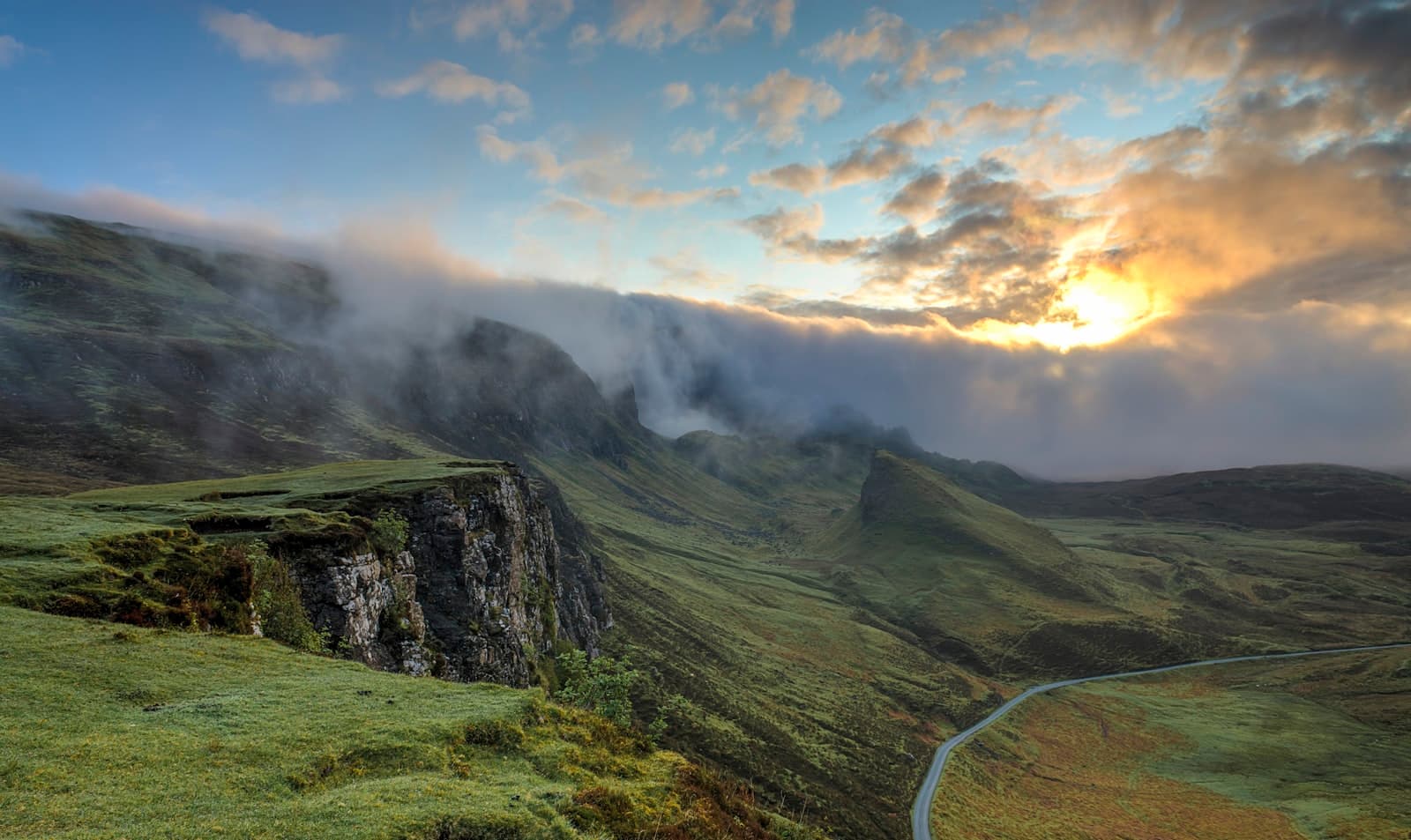 Soft mist lifting off green mountain ridges as the sun breaks through